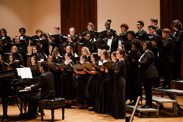 man playing piano in front of singing choir