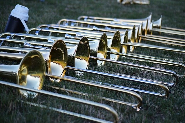 Photograph of trombones lined on field.