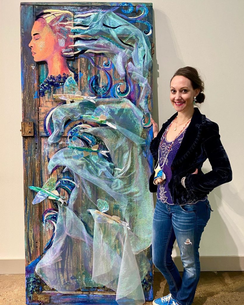 Marnée Wiley with large painting of woman on door with colorful hair