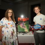 Throwdown Champion Christy Legros and assistant posing in front of artwork