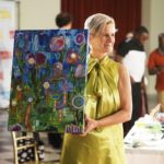 Angela Montgomery holding Katie Thompson's painting at 12th Annual Throwdown