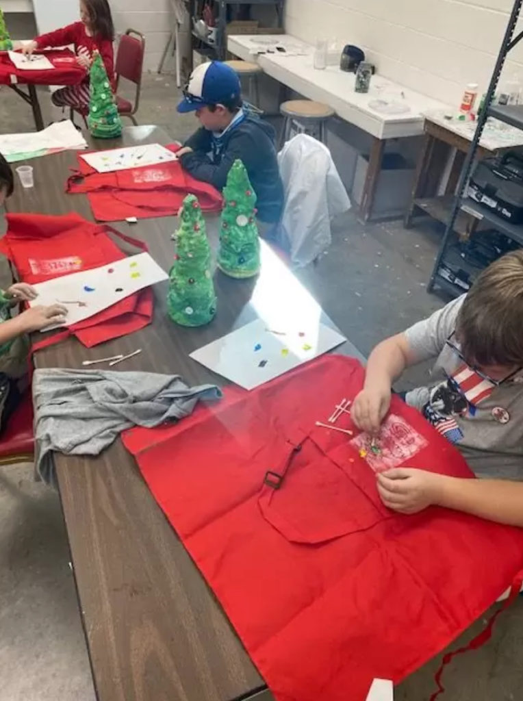 Students at Eastern Shore Art Center painting their own apron for Holiday Extravaganza