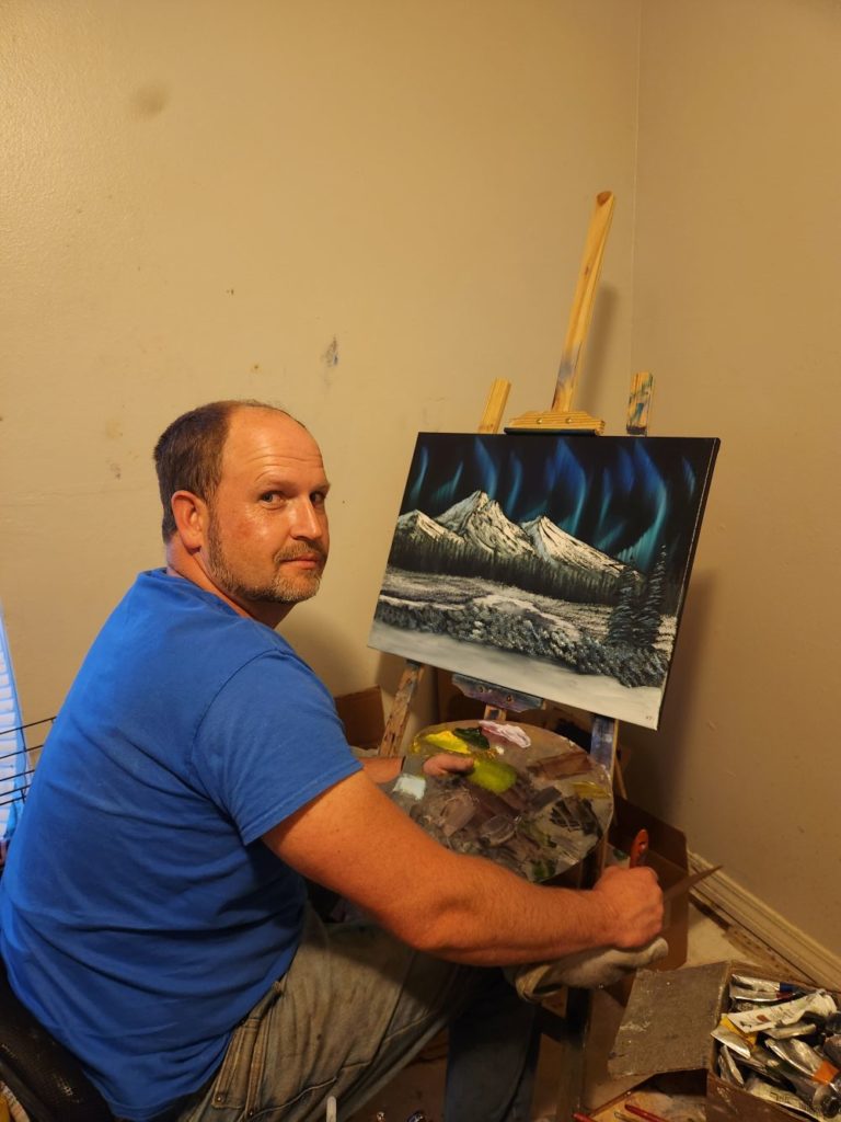 Cade Thornton painting a landscape in his studio