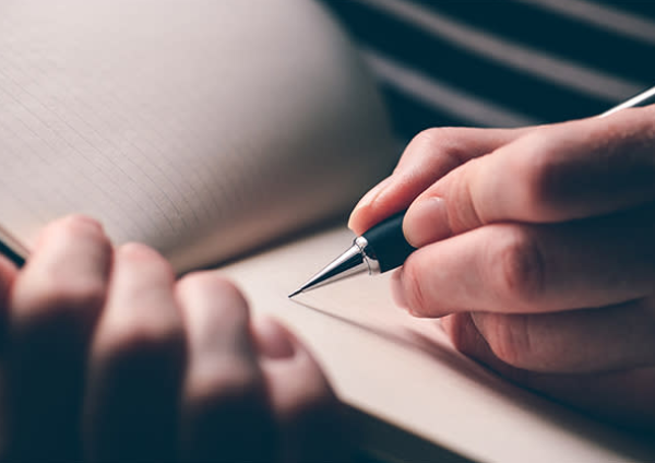 person writing in notebook